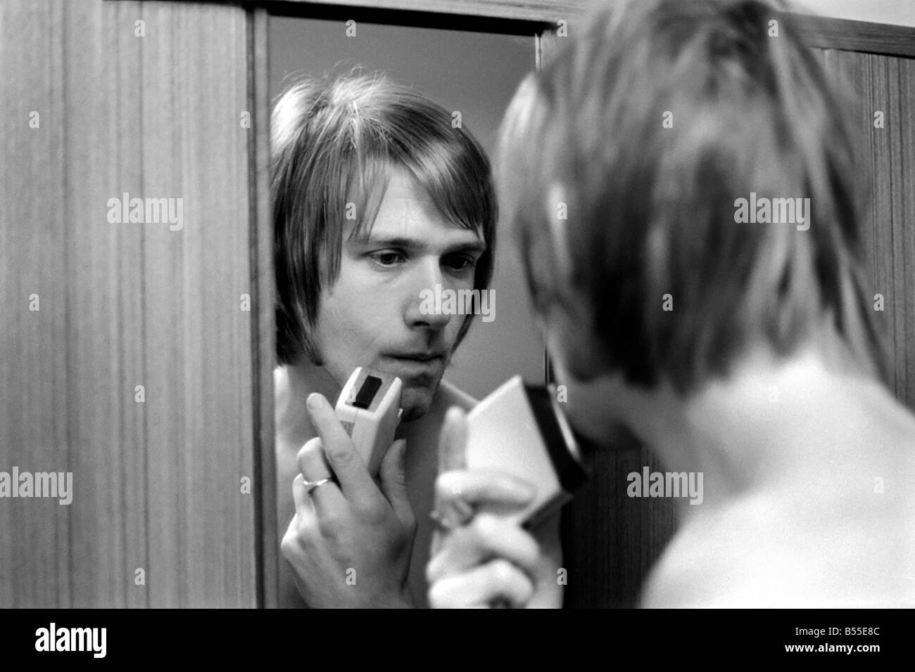 Manchester United fiery controversial player John Fitzpatrick who will appear before the F.A. disciplinary committee at Derby today. How awakes early collects the milk has a breakfast hug from his wife Barbara aged 21. Cleans his shoes, shaves, and kisses his wife goodbye. Then off to meet the Boss Wilf McGuiness at Manchester United Ground where he follows McGuiness to the car and sets off to Derby. November 1969 Z12019-010 Stock Photo