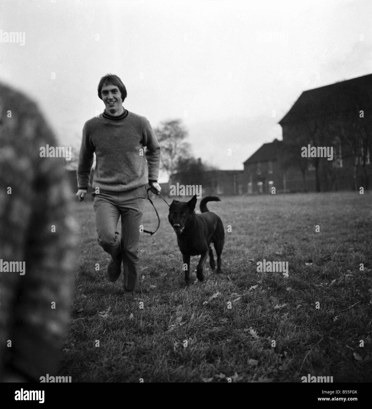 Derek Jeffries takes his dog Blackie for a run in a park near his home in Longsight, Manchester. ;He is in the first team squad Stock Photo