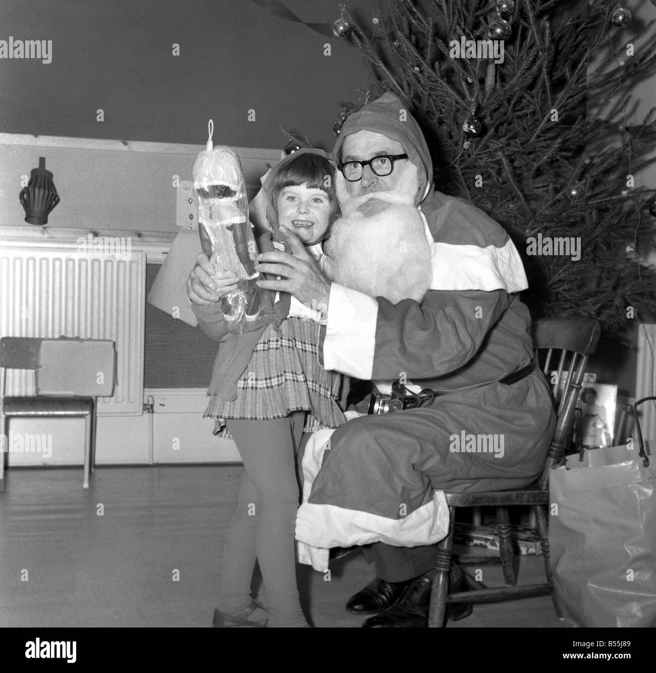 When Father Christmas is on duty handing out toys and gifts to children, children become enraptured with the bewhiskered figure Stock Photo