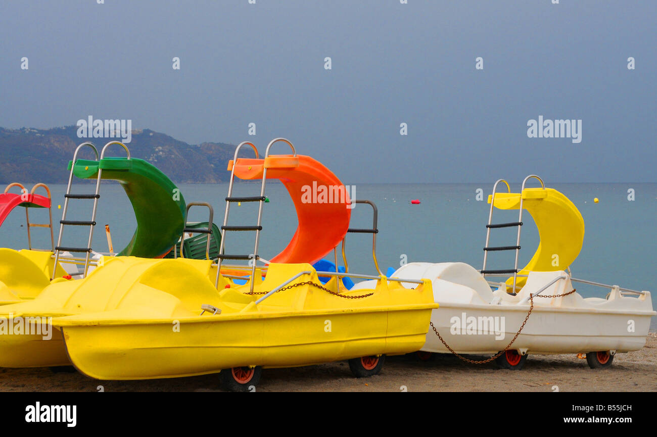 Brightly coloured Pedalo pedal boats on a deserted beach on Spain's