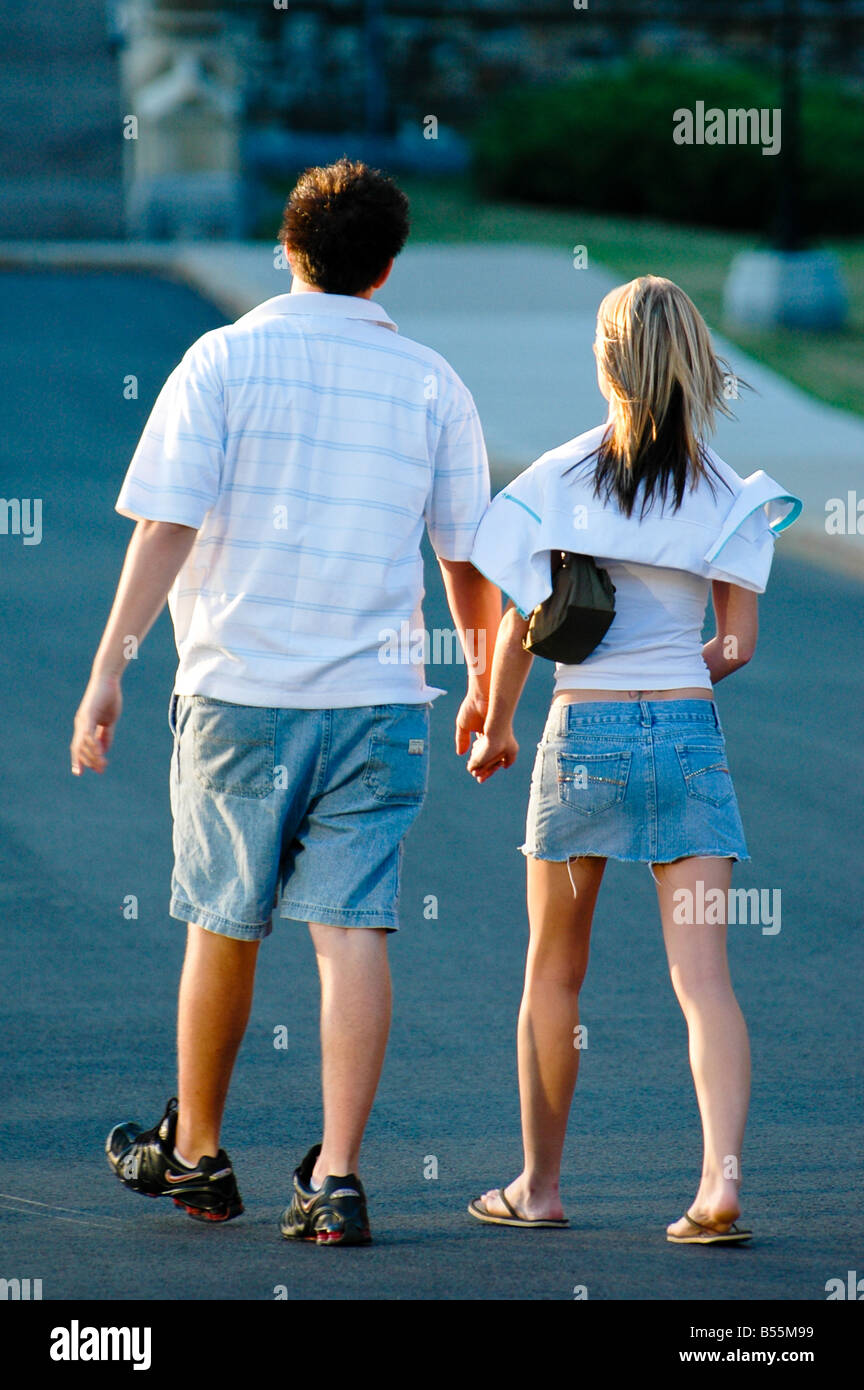 A couple of romantics walk hand in hand down the street. Stock Photo