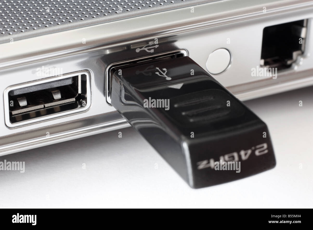 USB ports plus a modem port on the side of a notebook with a wireless mouse receiver stick on one of them Stock Photo