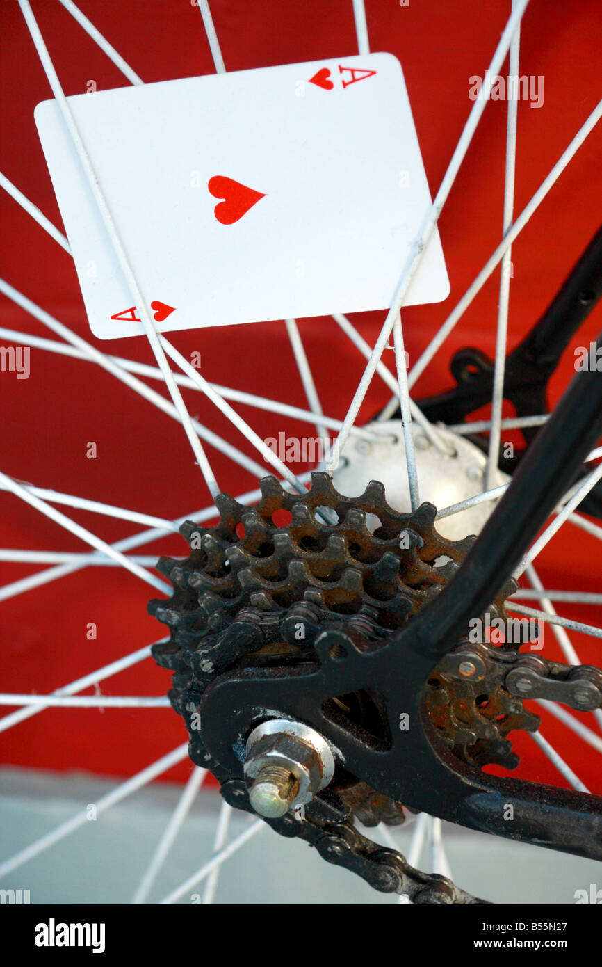 The Ace of Hearts playing card stuck into a bicycle rear wheel spokes Stock Photo