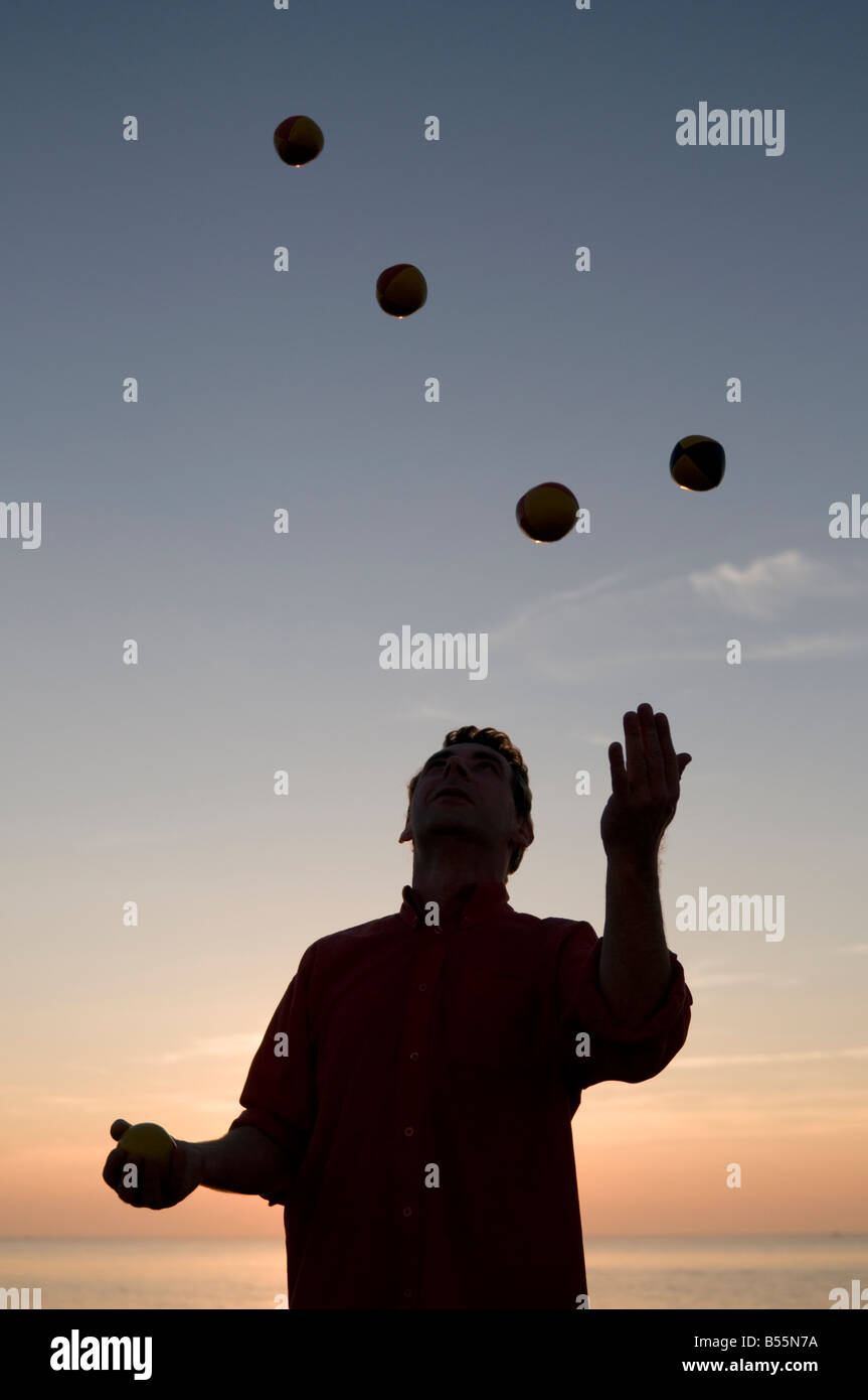silhouette of man juggling with four balls at sunset Stock Photo Alamy