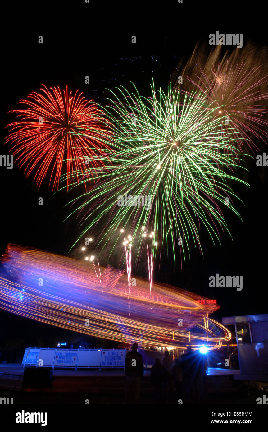 Fireworks and spinning fairgorund ride Stock Photo - Alamy