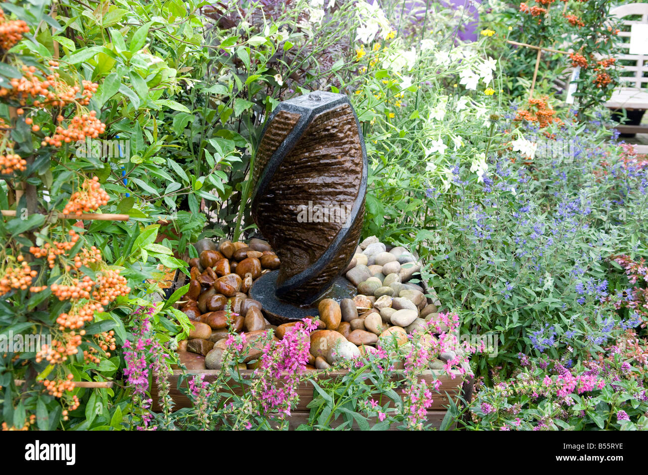 Small water feature in flower bed Stock Photo - Alamy