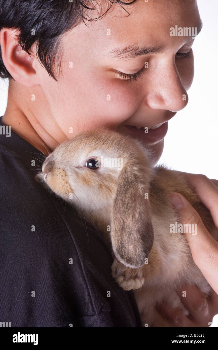 Young smiling boy holding his seven weeks old rabbit Stock Photo