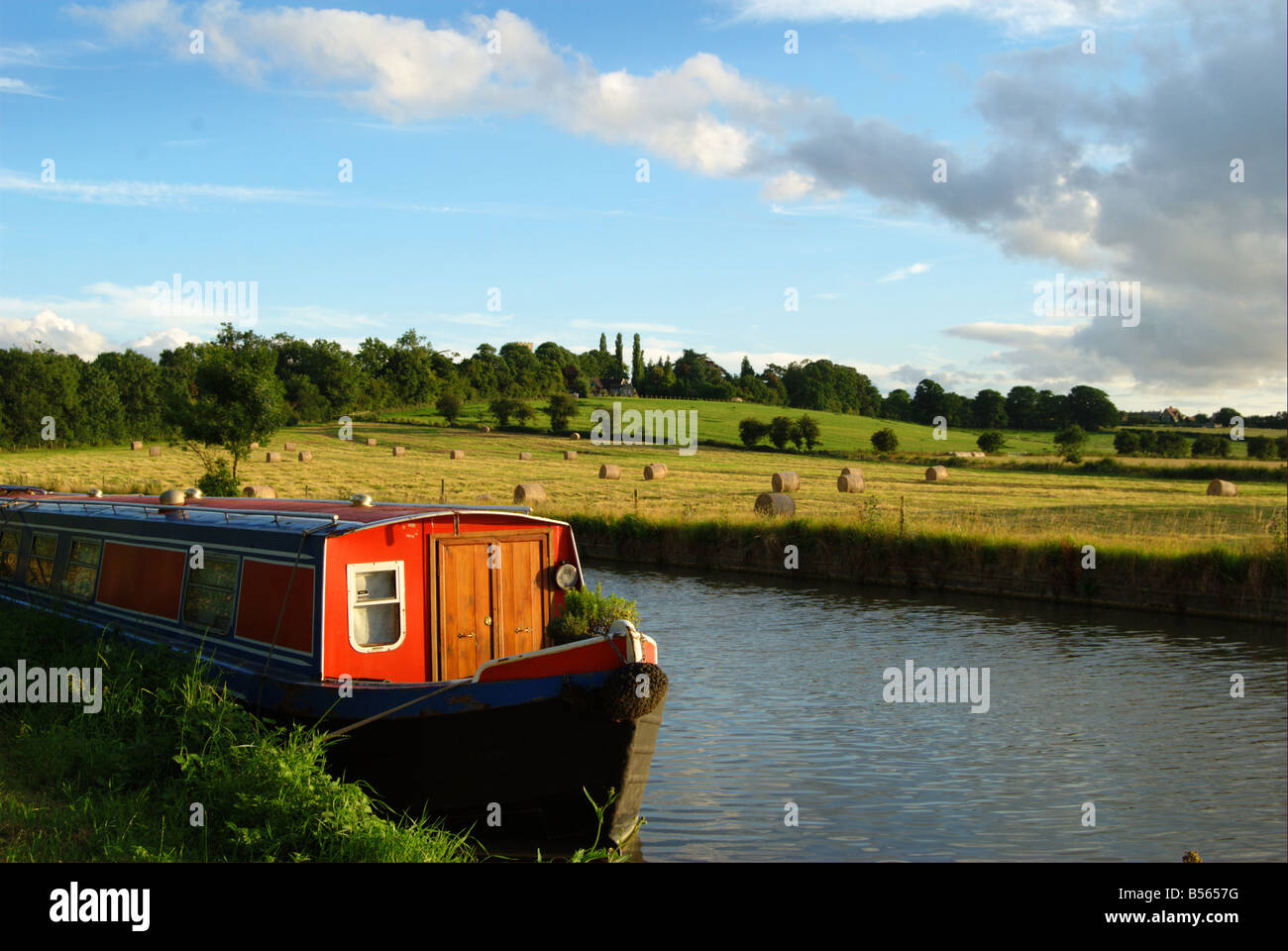 Canal Boat / Narrow Boat in late summer with Bales in Background. Stock Photo