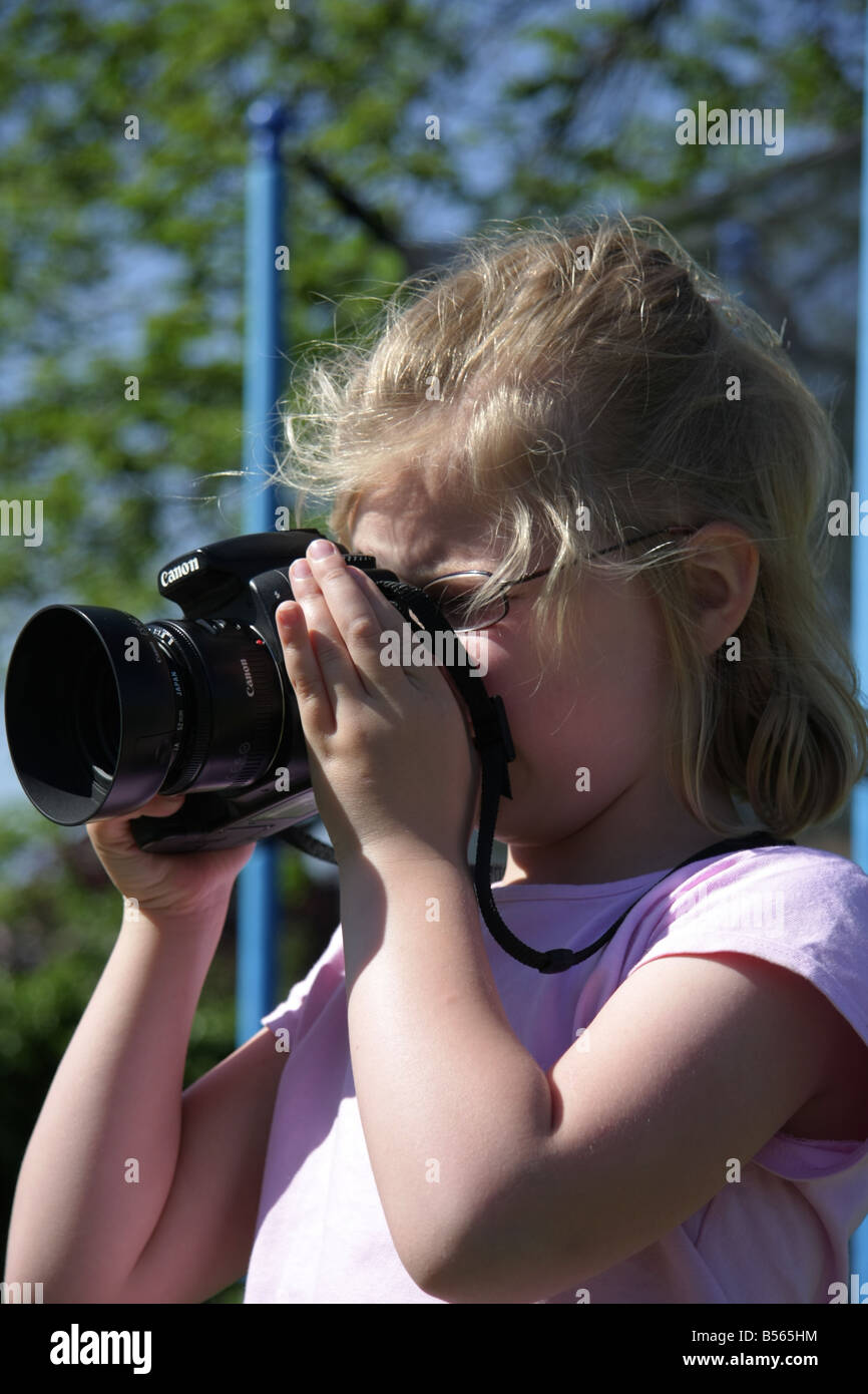 A young girl holding a digital slr camera. Stock Photo