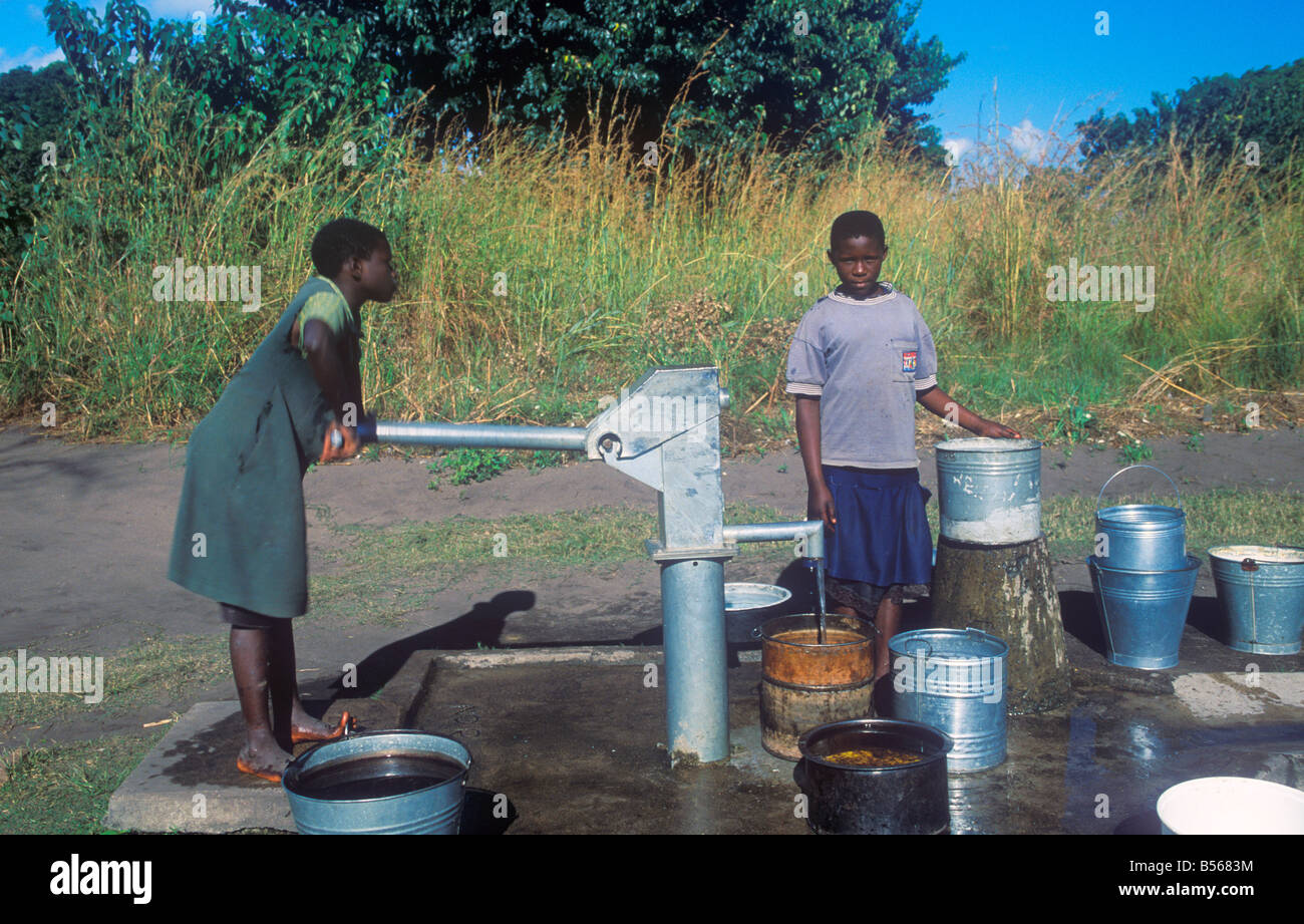Girls Pumping Water At A Water Pump In A Village At Lake Malawi Africa Stock Photo Alamy