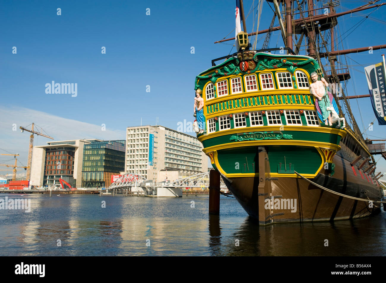 Old sailing ship 'Amsterdam' on display at Maritime Museum Scheepvartmuseum in Amsterdam with new office developments to rear Stock Photo