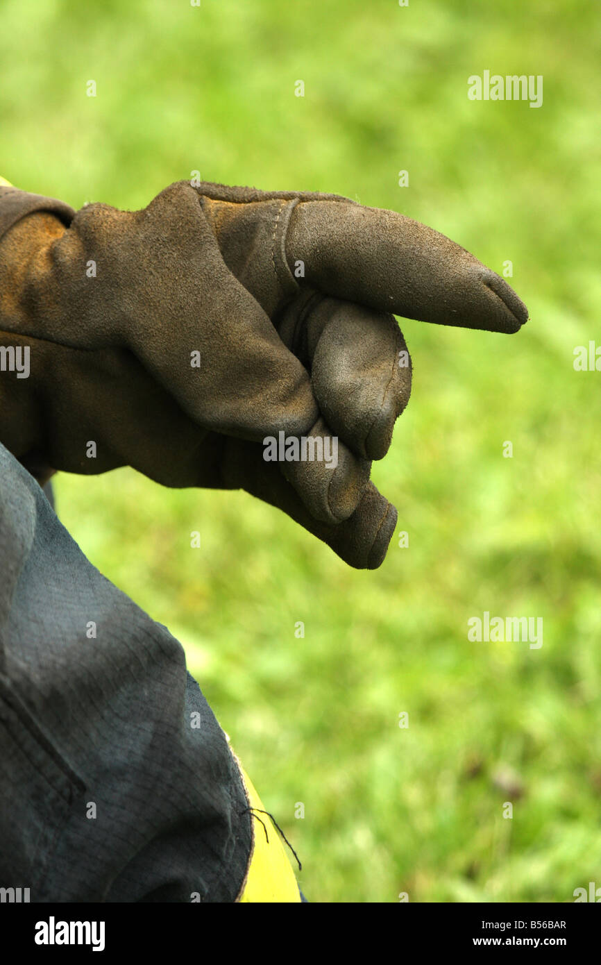 The protective leather glove of a firefighter kneeling at a fire scene