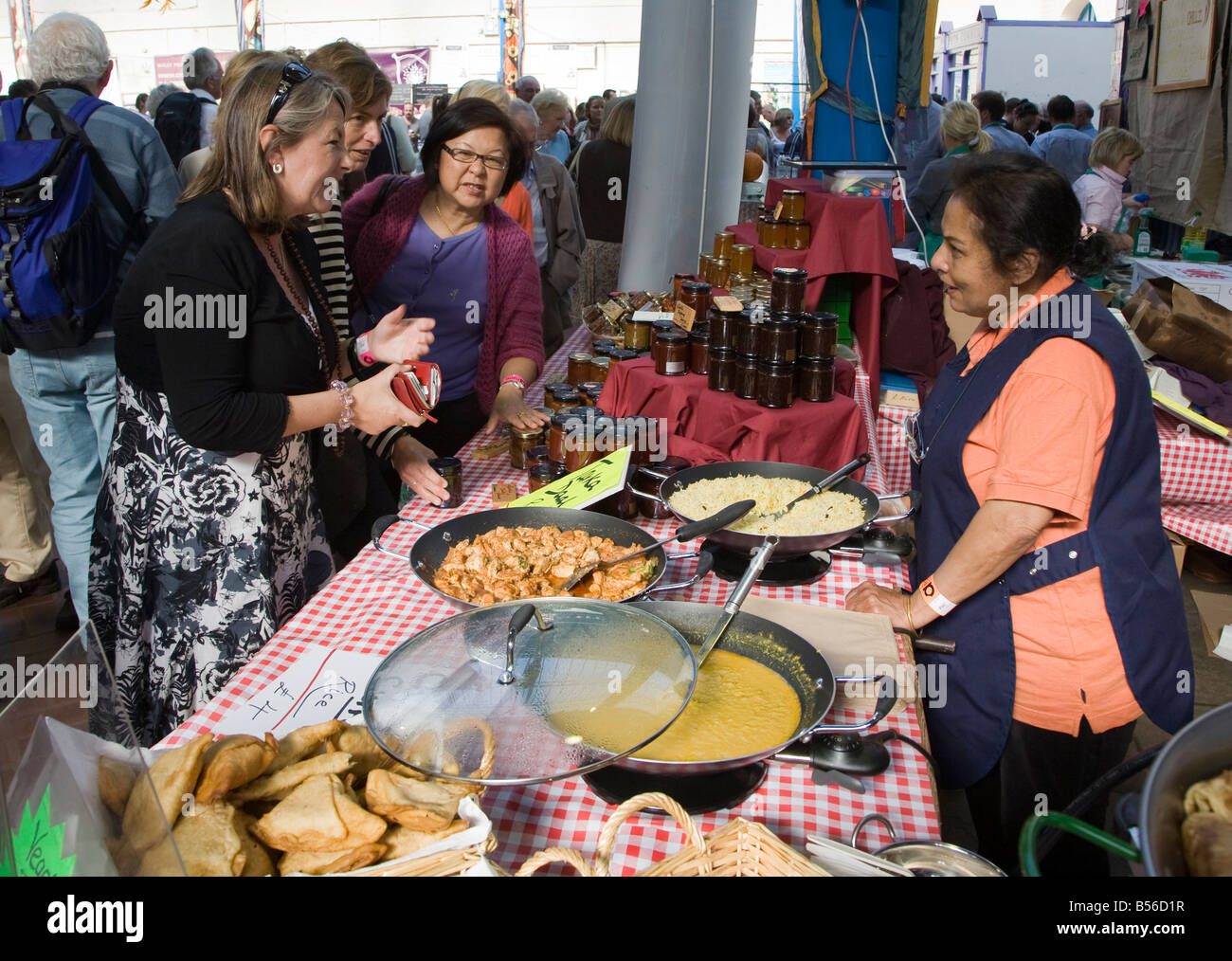 Woman serving Indian food at Abergavenny Food Festival Wales UK Stock Photo