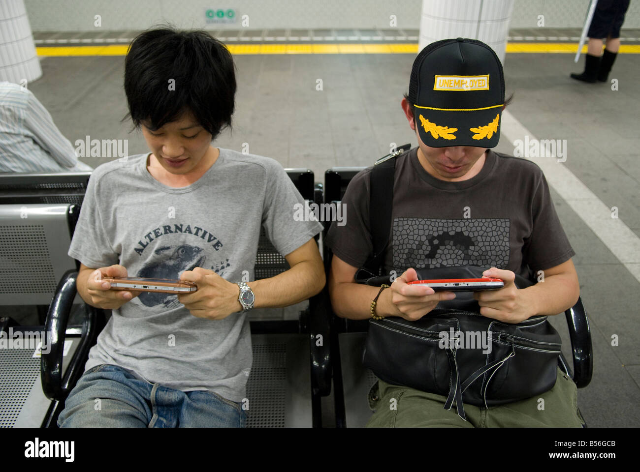 Two Japanese boys playing with a PSP in the Tokyo subway. Stock Photo