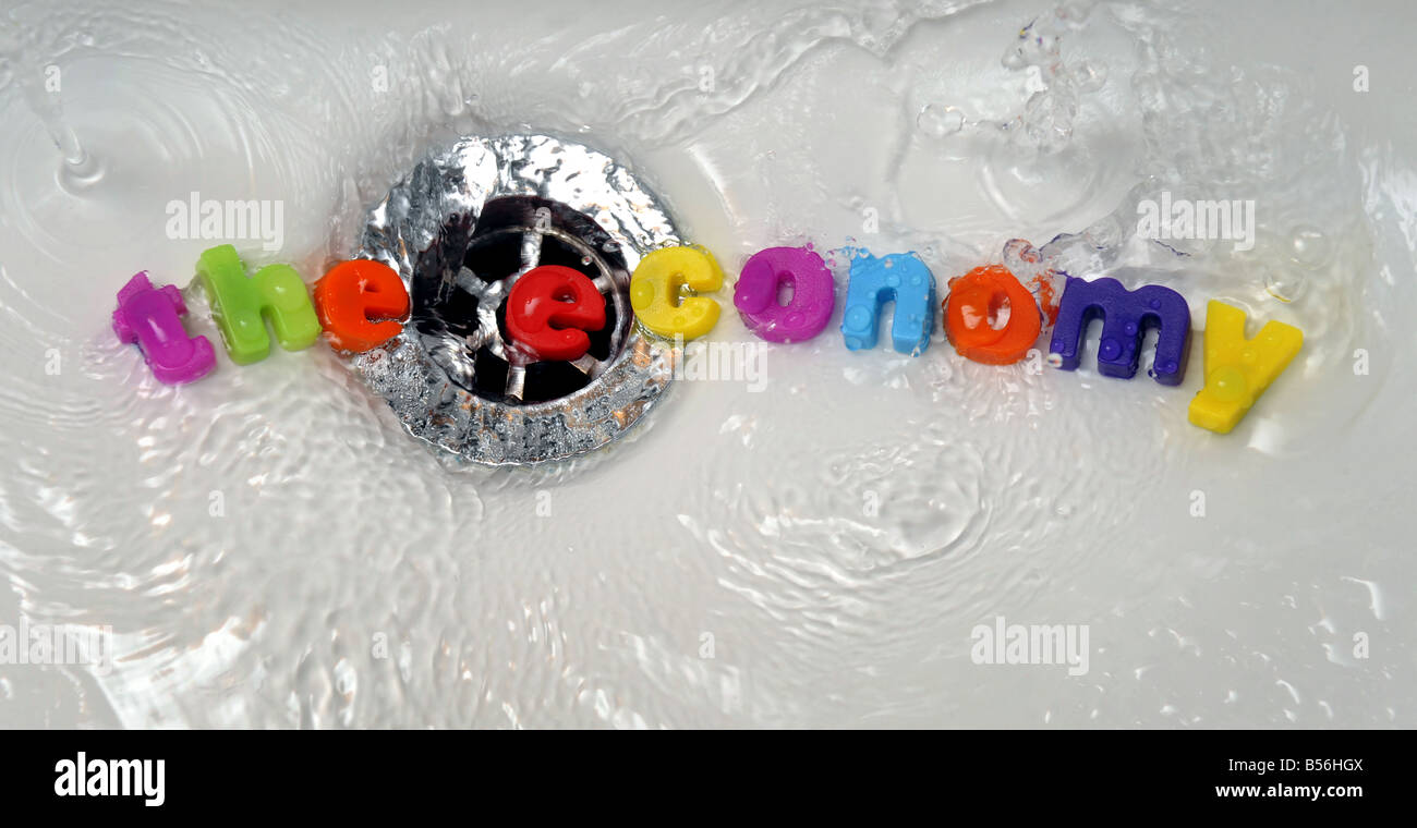 'THE ECONOMY' GOING DOWN  THE DRAIN/PLUGHOLE....WORDS SPELLING 'THE  ECONOMY' ARE WASHED DOWN A PLUGHOLE BY WATER. Stock Photo
