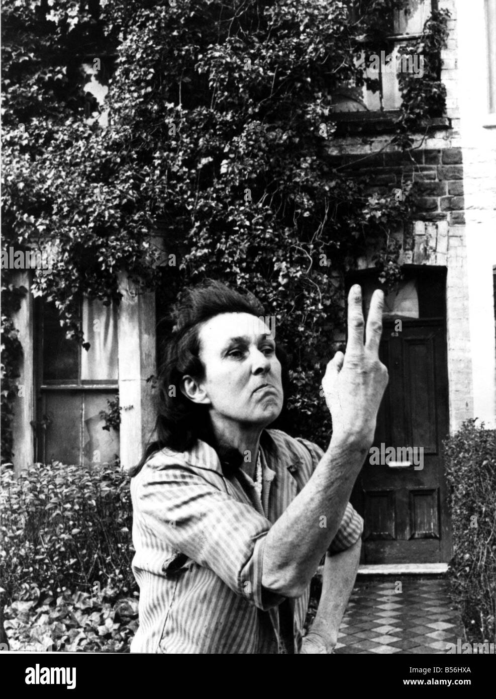 Animal lover Miss Margaret Williiams outside her house in Richards Street Cathays were she lives with her dogs and cats shows her feelings towards her nosey neighbours with a two fingered salute 25th Feburary 1977 Western Mail and Echo Copyright Image Stock Photo