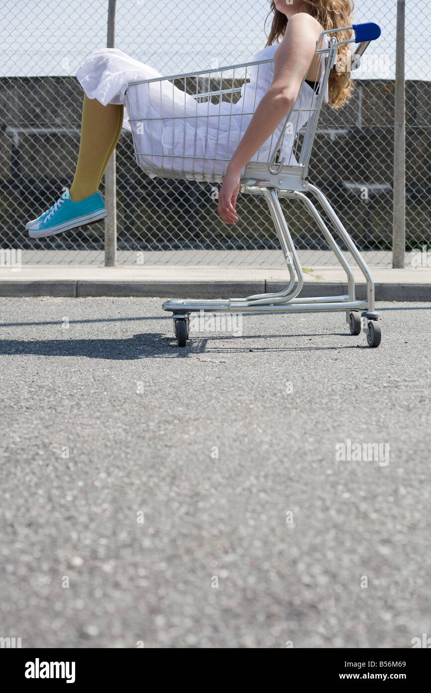Woman sitting in a shopping trolley Stock Photo