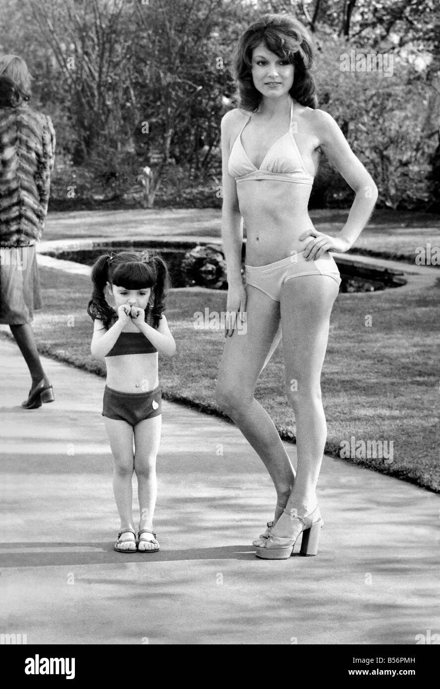 Fashion scene from Woolworth's. Woman wearing a bikini standing in the park  with a little girl;February 1975 ;75-01132-003 Stock Photo - Alamy