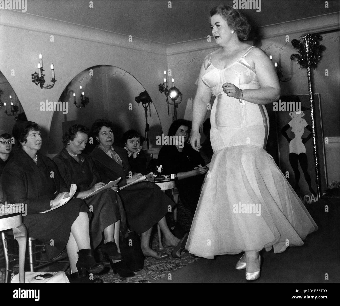 Woman wearing long frilly white dress as a row of judges sit behind making notes&#13;&#10;Circa 1955 &#13;&#10;P010054 Stock Photo