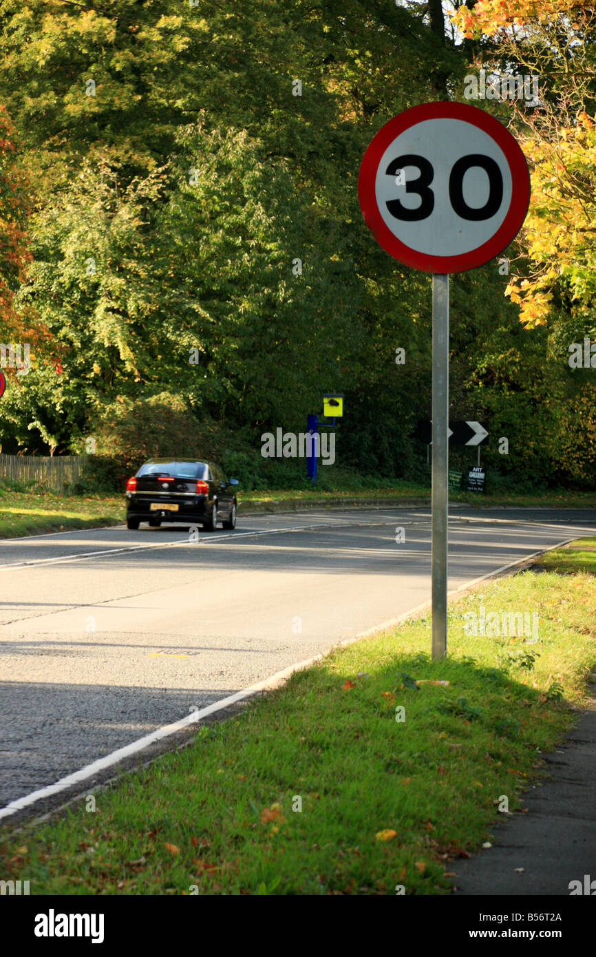 A speed limit sign with a speed camera in the background.Portrait format Stock Photo