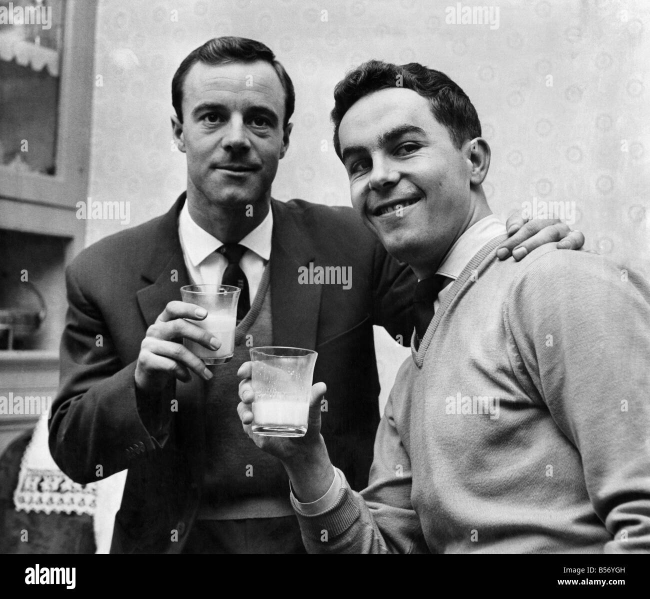 After having treatment for a leg injury (received in training) Bolton inside forward Ray Parry visited his pal Peter Deaking who will play in Ray's place if he is declared unfit. A smiling Peter (right) is joined in a glass of milk by Ray as they wonder who will play against Bury in the cup tie. January 1960 P009934 Stock Photo