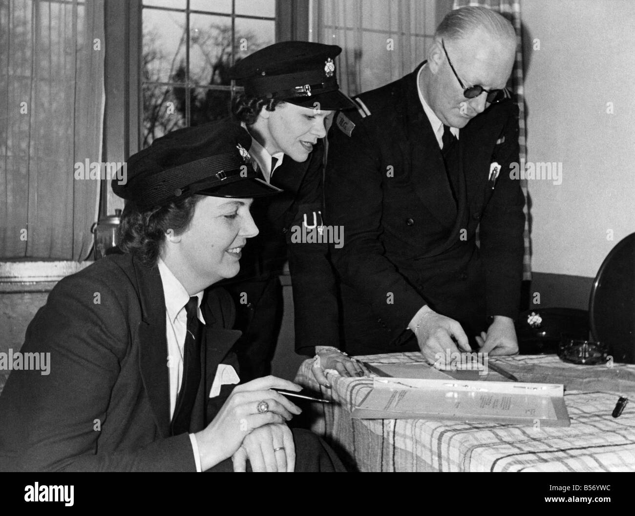 World War II Women. Mrs. W.C. Thiele (right) and Mrs. P. Bartlett who are the helmsmen of Patrol Launches of the Upper Thames Patrol (Home Guard). Pictures taken at Maidenhead where they have been on active service since the inception of the U.T.P. Lieutenant Thiele is seen giving instructions for there night patrol duty. January 1941 P010106 Stock Photo