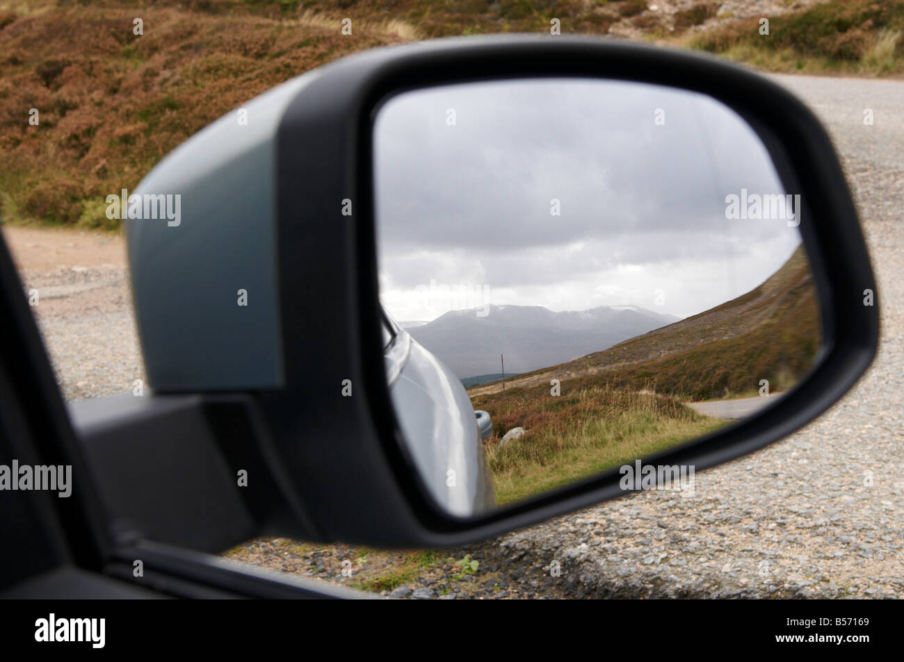 Ford Mondeo parked on verge of road with Grampian Mountains in background through mirror on A944 Scotland UK Stock Photo