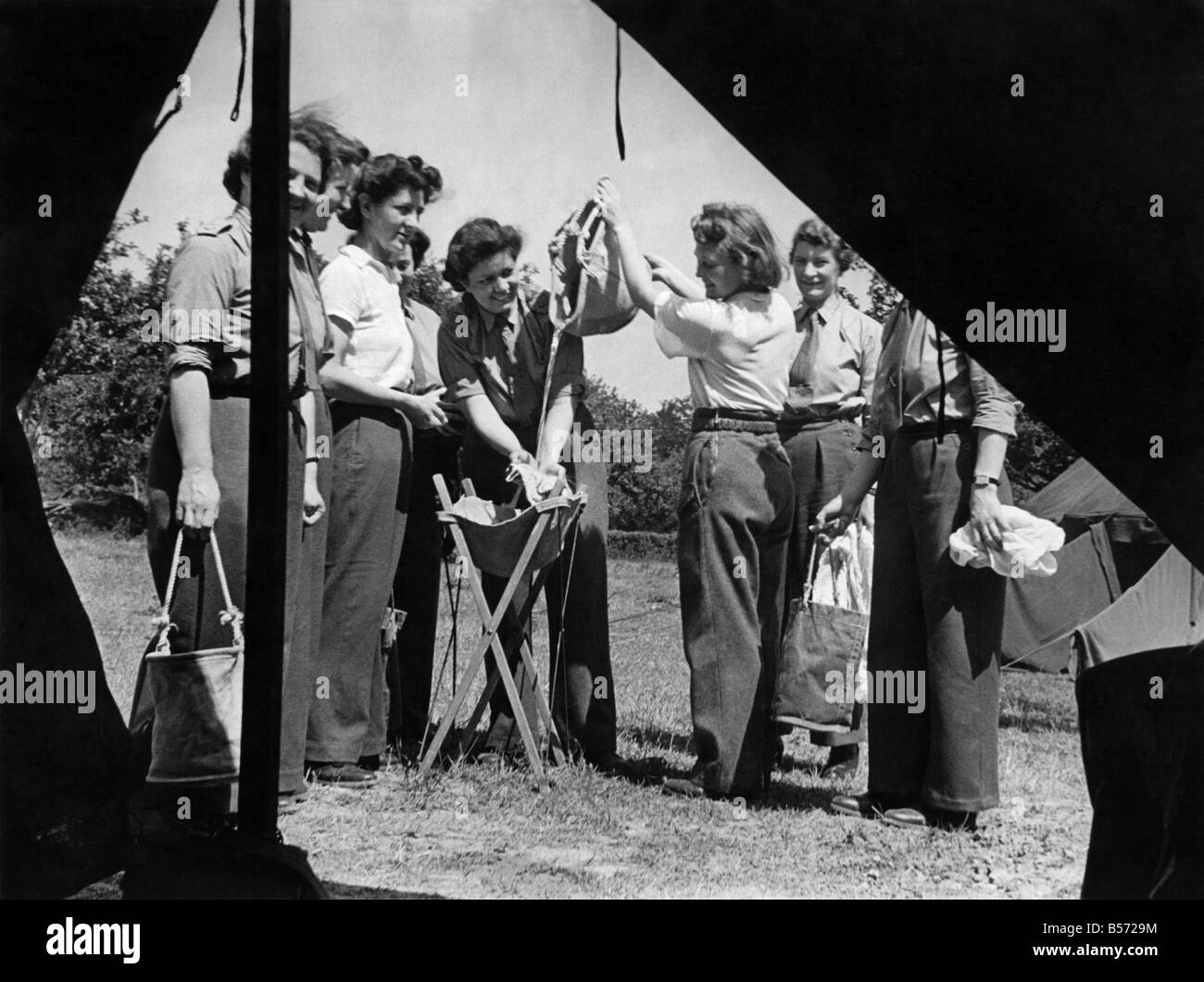 World War II Women: A.T.S. girls on holiday. Women washing their smalls outside their tent. July 1944 P010198 Stock Photo