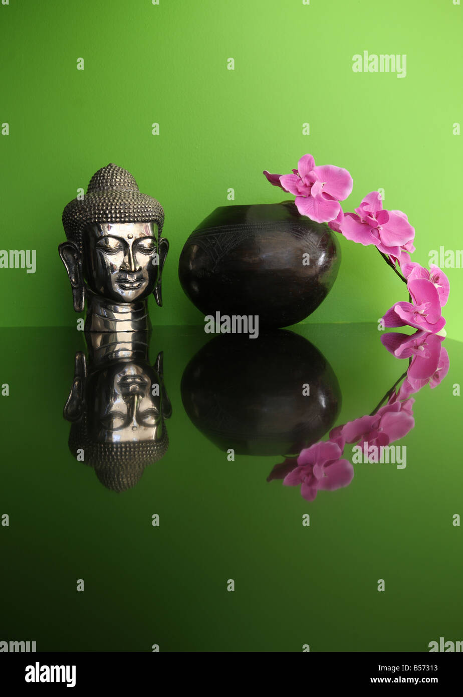 Buddha Head and Pink Orchid against a green backdrop Stock Photo - Alamy
