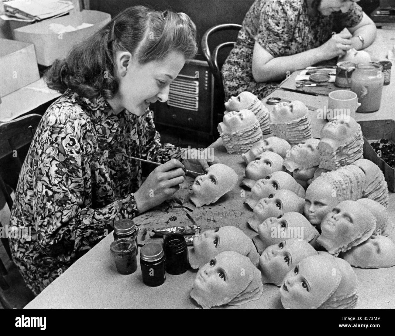 Utility Dolls for Christmas. The Board of Trade has released material for the manufacturers of utility dolls. A lot of the stuff is hygienic salvage from munition factories. The popular doll is called Edna. Miss. Agnes Wright's Job is painting the eyes of the dolls. September 1943 P03716 Stock Photo