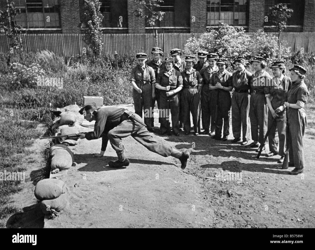 World War II: Women. Pictures taken at R.A.O.C. depot. outside London show some of the first A.T.S. volunteers taking instruction on Rifle Shooting at practise camp. A R.S.M. is seen demonstrating moving to a position. June 1942 P010185 Stock Photo