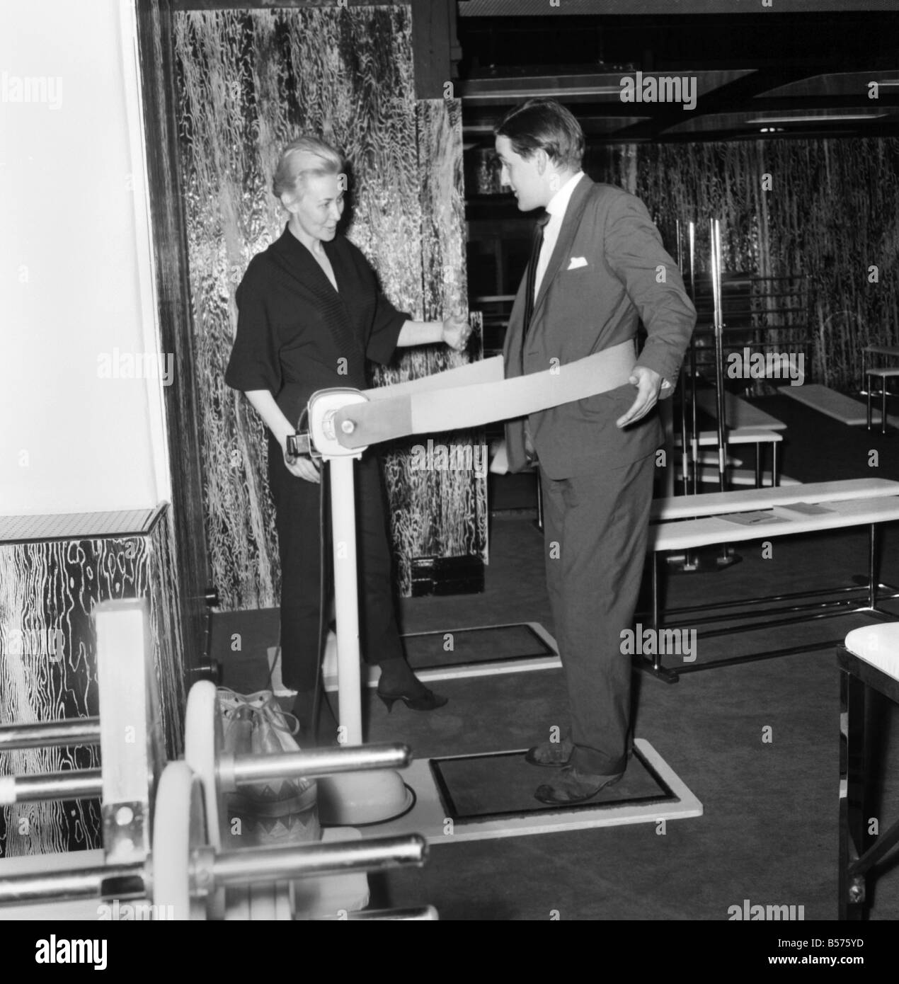 New Gymnasium opens in Oxford 'Street,' London. A potential gym member trys out one of the machines to keep trim. June 1960 Stock Photo