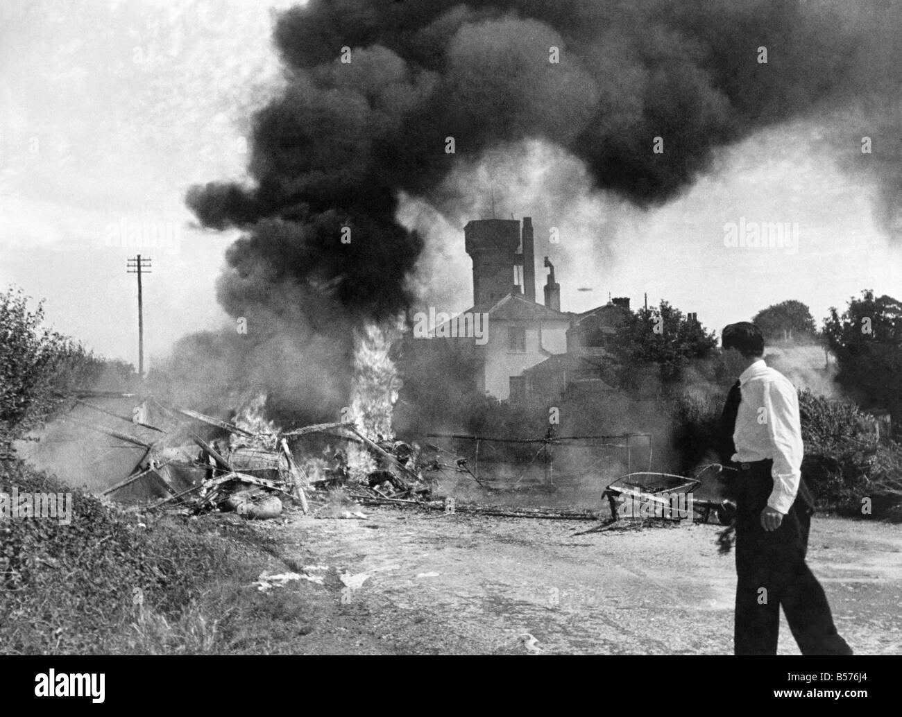 Blazing plane crash. An aeroplane with seven passengers abroad, crashed and burst into flames a few minutes after taking off from Heston Aerodrome for the King's Review of the Fleet at Spithead. Two of the pasengers died and four other passengers and the pilot injured. Our Picture Shows: The blazing wreckage of the machine. July 1935 P003924 Stock Photo