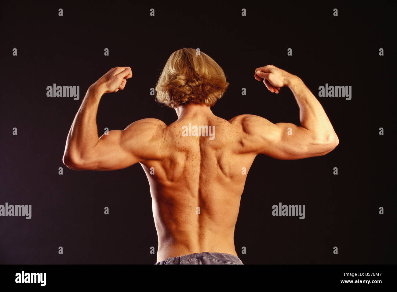 View of the back of male flexing his arms Stock Photo Alamy