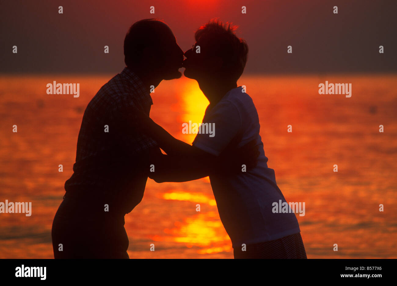 silhouette of a couple kissing at sunset at the beach of Kąty Rybackie ...
