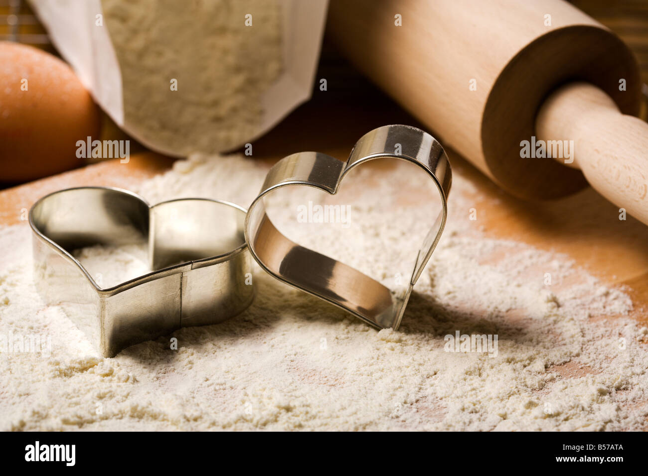 heart shaped cookie cutters in flour, rolling pin, pack of flour, eggs in  background Stock Photo - Alamy