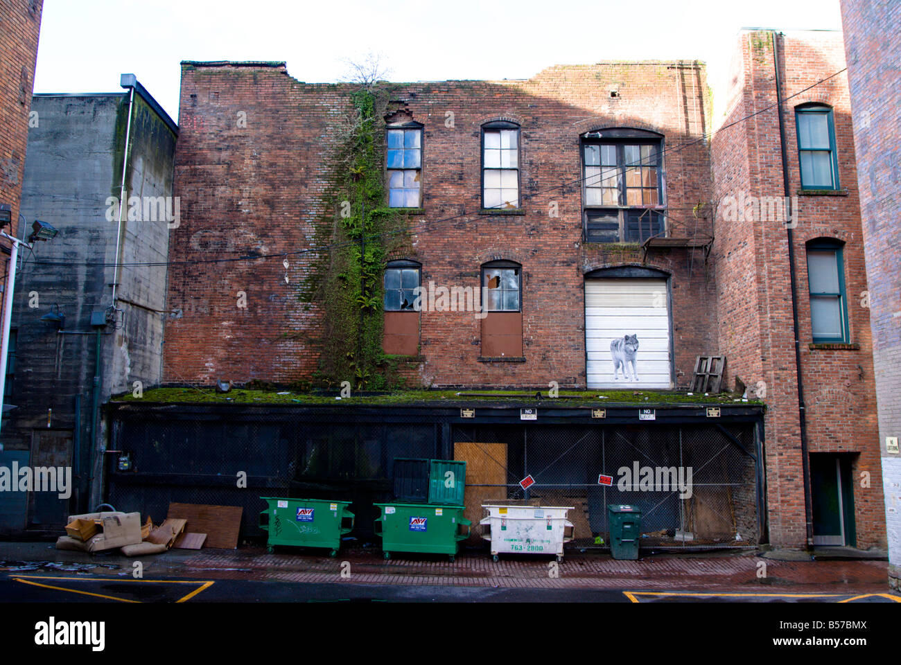 A colour photo of the rear of a Seattle downtown building from an alley with one side cleared to make a car park. Stock Photo