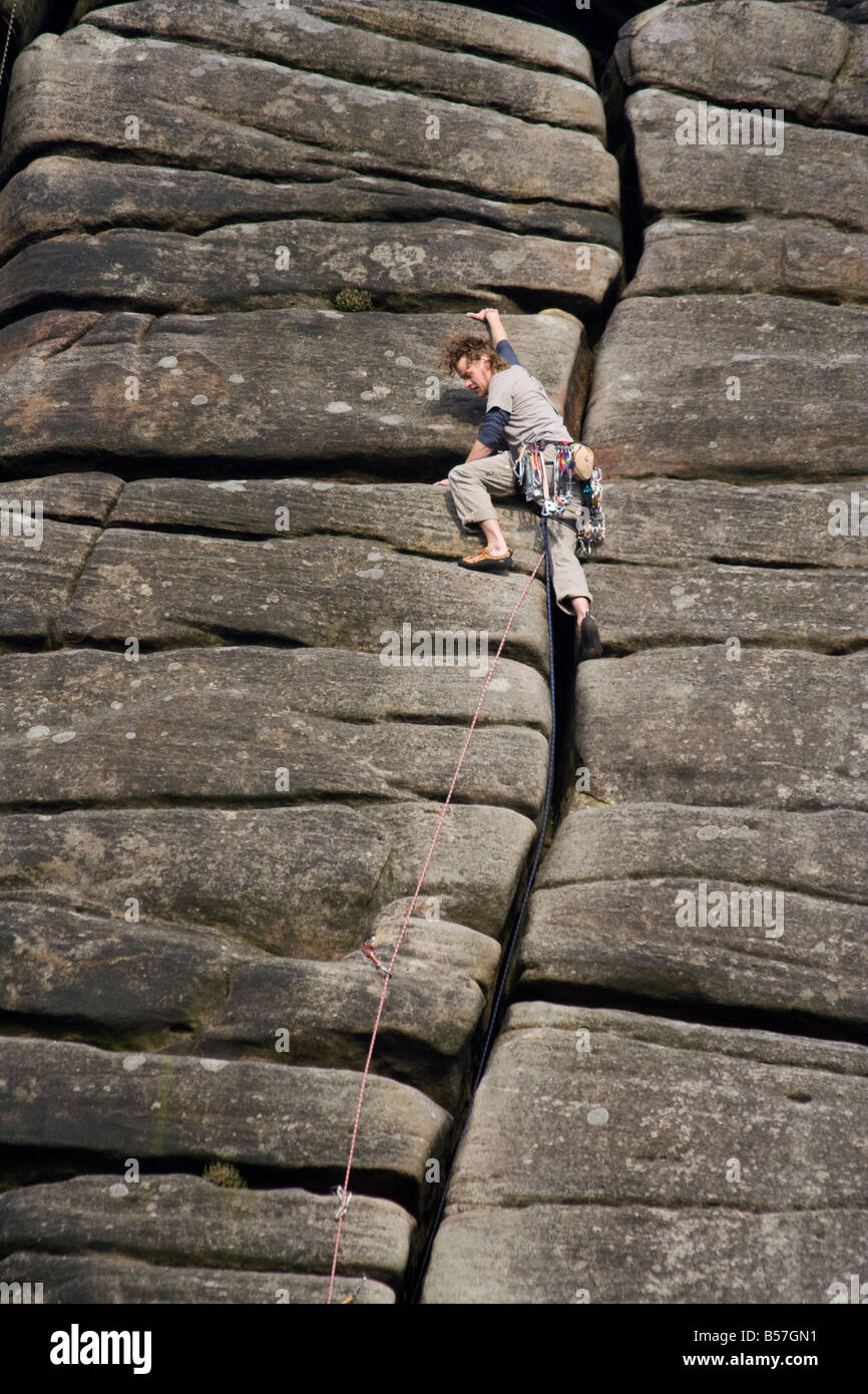Climber on crack in rock 'Stanage edge', Derbyshire Stock Photo