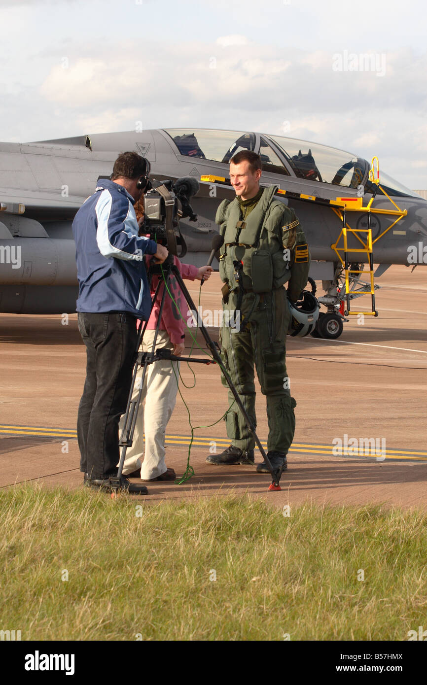 Jet fighter pilot being interviewed by local TV media press video camera crew Stock Photo