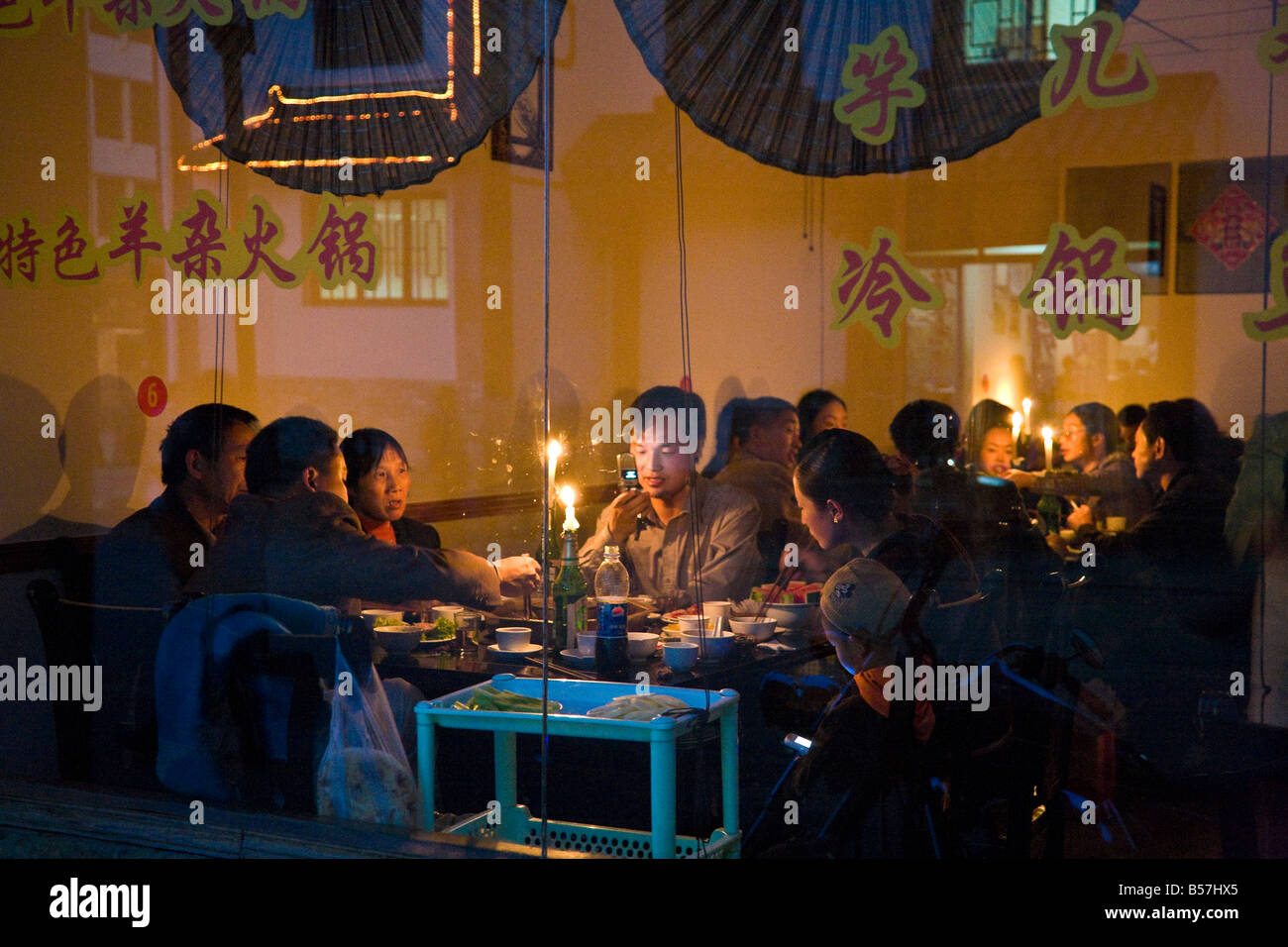Eating by candlelight in a restaurant in Songpan near Huanglong and JiuzHaiGou northern Sichuan China during power cut JMH3461 Stock Photo