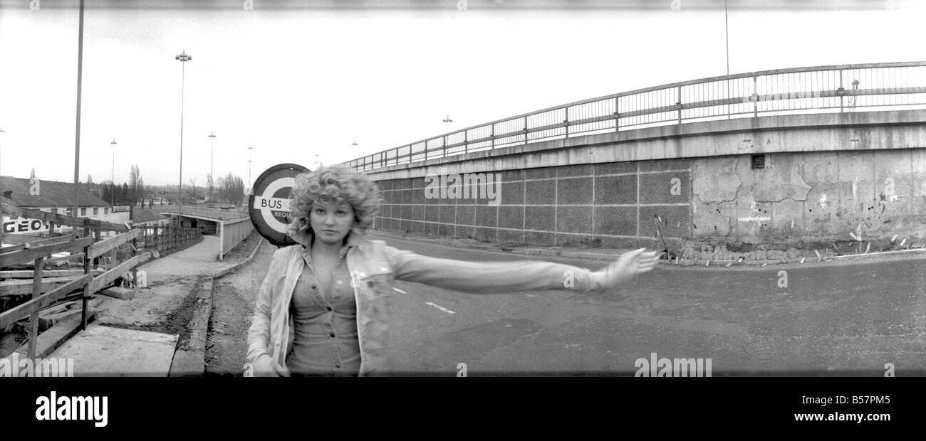 Model Angela Jay pictured here near her home in Hendon trying to stop a bus. The stretching of her arm is not done physically but photographically.;January 1975 ;75-00175 Stock Photo