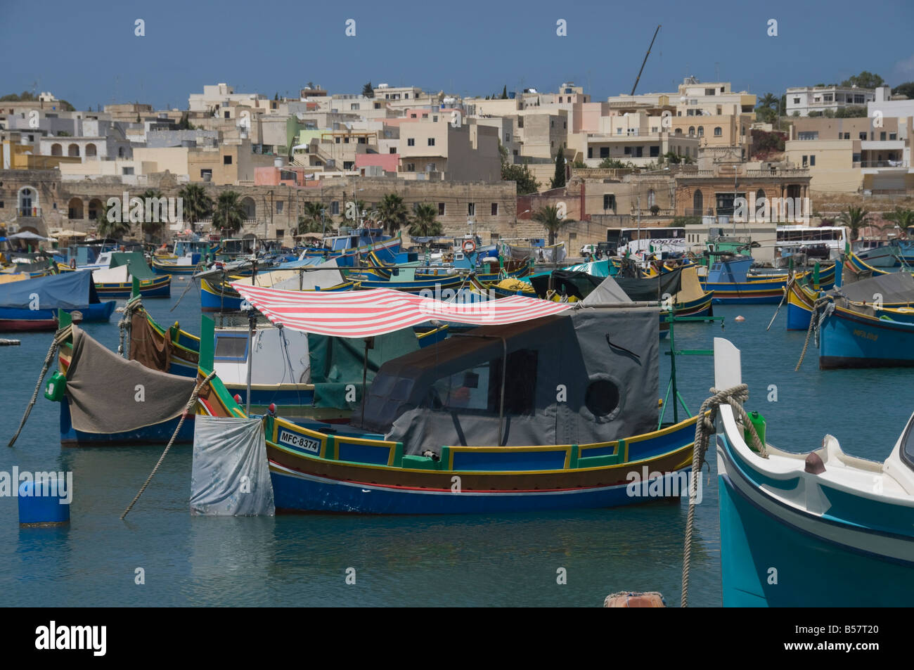 Brightly coloured fishing boats called Luzzus at the fishing village of Marsaxlokk, Malta, Mediterranean, Europe Stock Photo