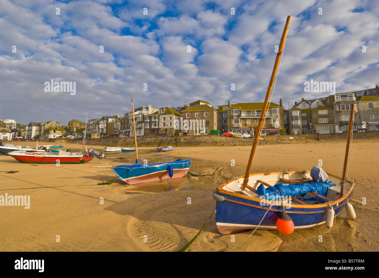 Strange cloud formation in the early morning with small Cornish fishing boats at low tide in the harbour at St. Ives, Cornwall Stock Photo