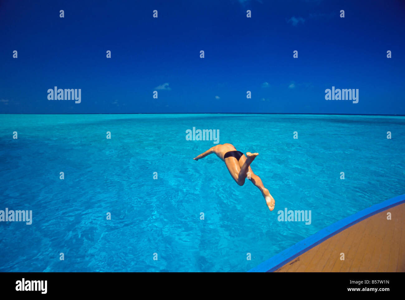 Man jumping into tropical sea from deck, Maldives, Indian Ocean, Asia Stock Photo