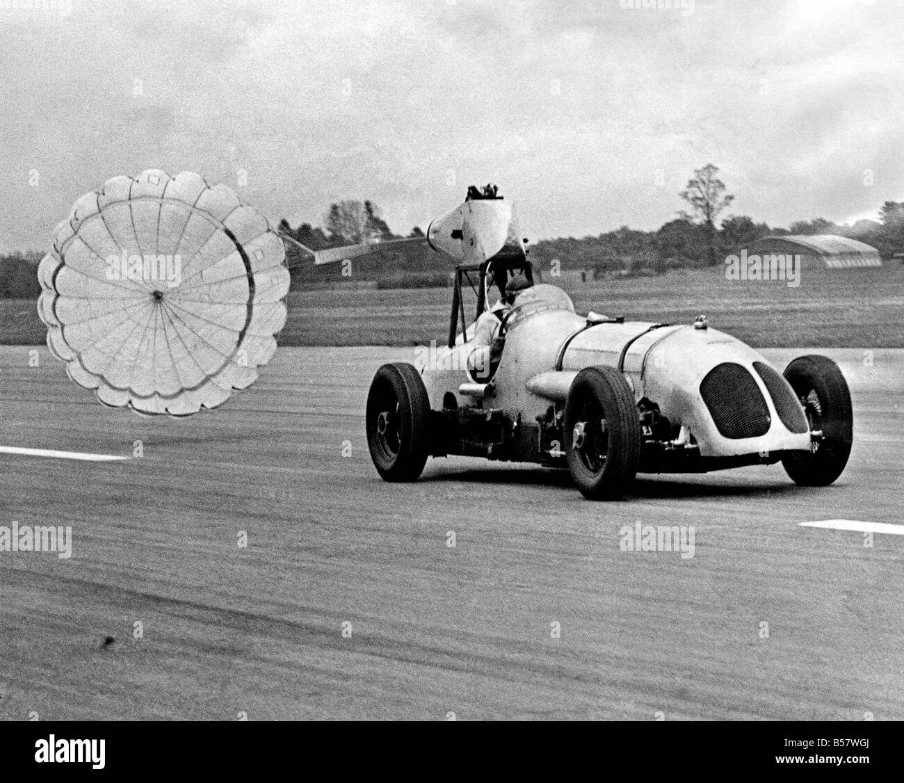 A demonstration of the G.Q. retractable aircraft brake parachute took place today at Dunsfold aerodrome, and the test vehicle used was a racing car which set up its first lap record at Brooklands in 1933. ;May 1954 ;P004672 Stock Photo