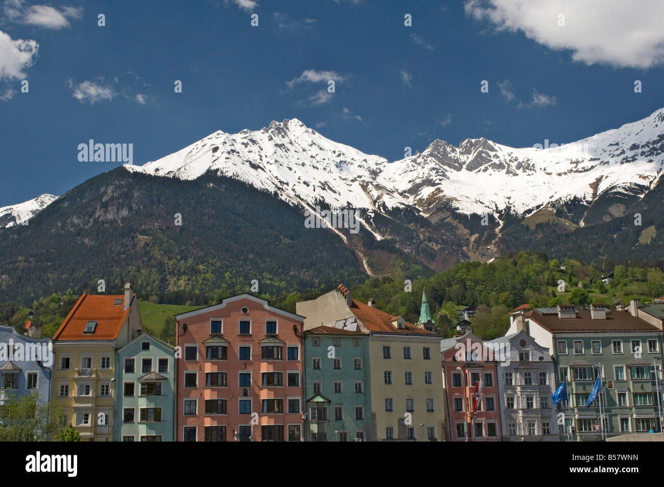 Candy coloured houses with backdrop of mountains in spring snow