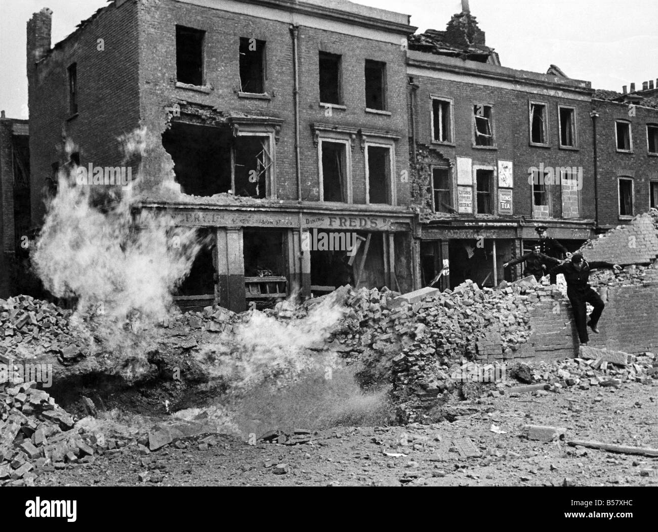 V1 Flying bomb incident at East Smithfield causing damage and casualties - also fractured gas and water mains-the gas main was well alight and although the water was gushing out almost along-side it the heat was terrific. Troops were quatered on the Thames Bank but escaped with slight injuries. August 1944 P009473 Stock Photo