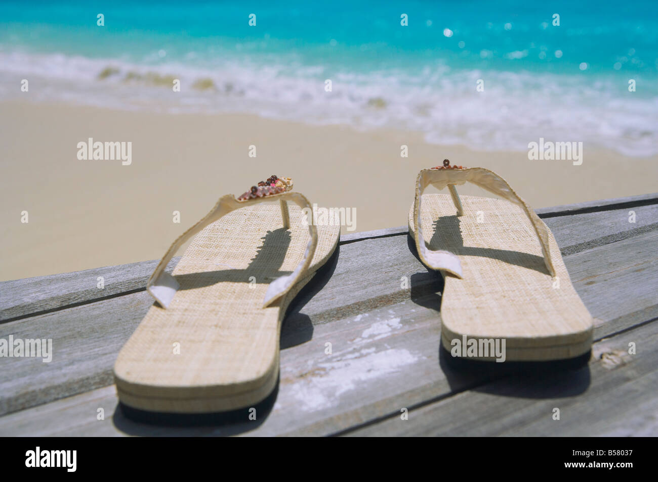Pair of slippers on deck on beach Stock Photo