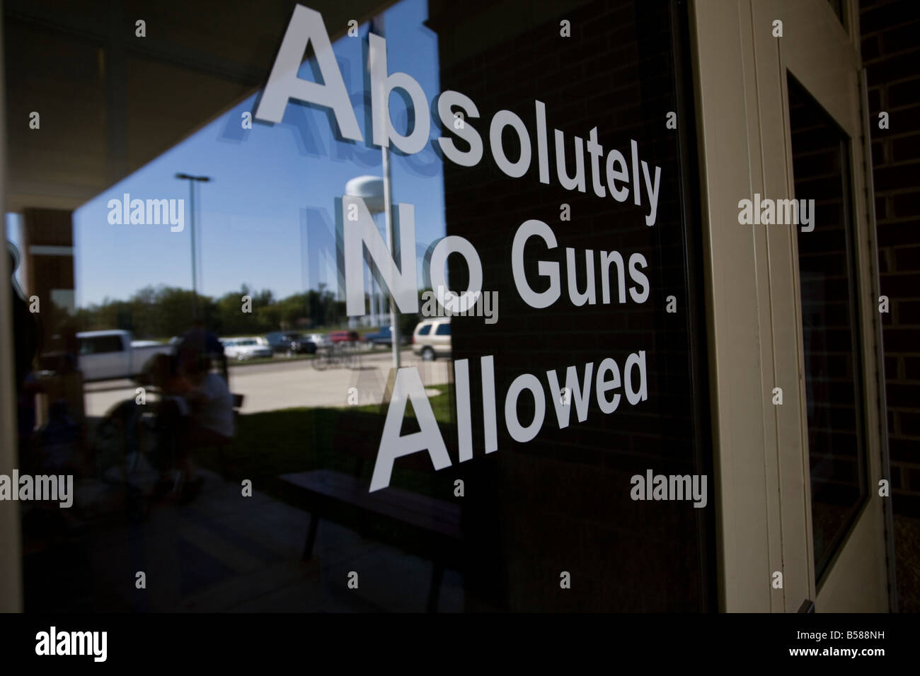 The "Absolutely No Guns Allowed" sign on the entrance door of a Saint