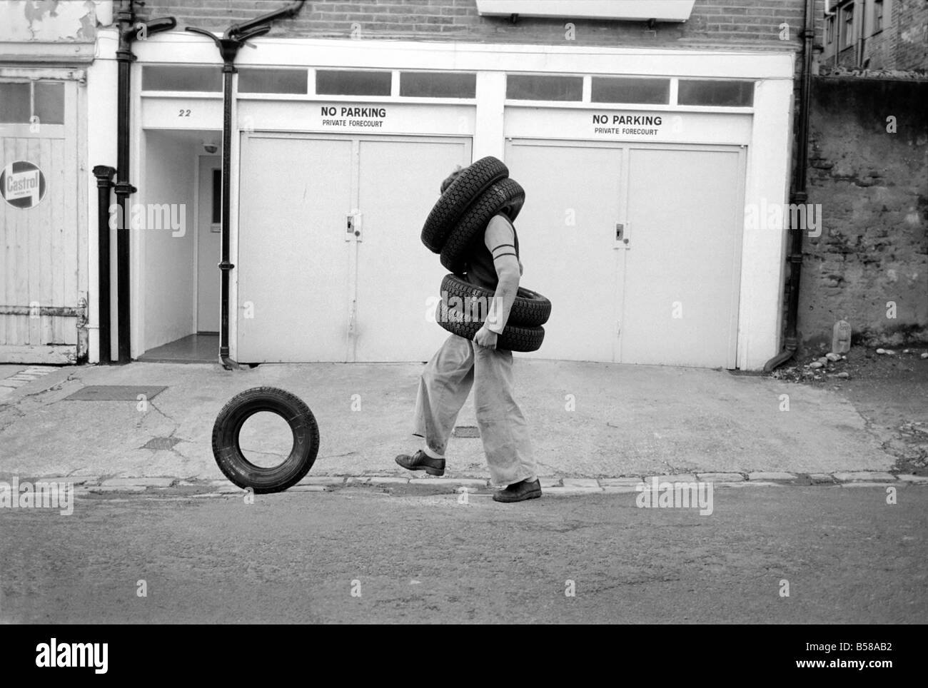 Unusual/Man/Tyres/Humour/Comedy. All Tyred up Brighton Tyre Fitter. February 1975 75-00991-001 Stock Photo